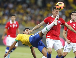 Brazil's Paulinho (left) tries to clear the ball away from by Chile's Eduardo Vargas (centre) and Eugenio Mena