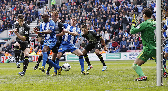Wigan Athletic's Emmerson Boyce (2nd from left) deflects the ball past his goalkeeper Joel Robles (right) to concede an own goal during their English Premier League match against Tottenham Hotspur on Saturday