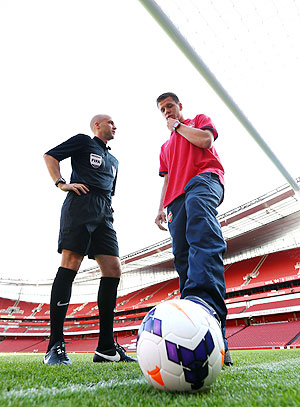 Referee Anthony Taylor discusses the new technology with Arsenal goalkeeper Wojciech Szczesny during the Goal Decision System (GDS) media event at the Emirates Stadium in London on Thursday