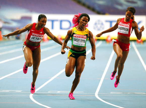 Shelly-Ann Fraser-Pryce of Jamaica (centre) crosses the line to win gold in the women's 100 metres