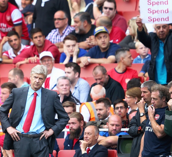 Arsene Wenger of Arsenal looks on as a fan behind makes his feelings known