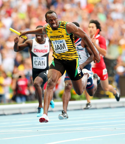 Usain Bolt of Jamaica crosses the line first win gold in the Men's 4x100 metres final