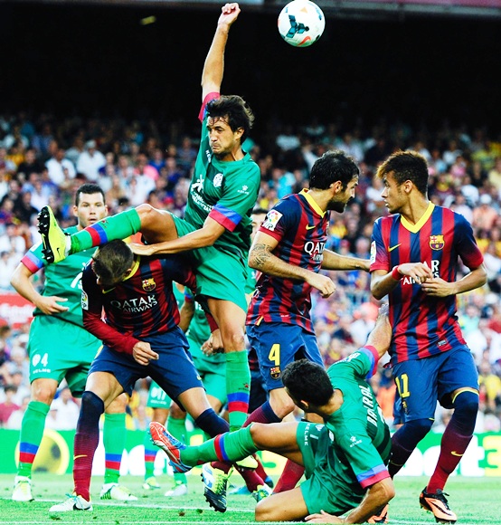 Gerard Pique of FC Barcelona duels for a high ball with Hector Rodas of Levante