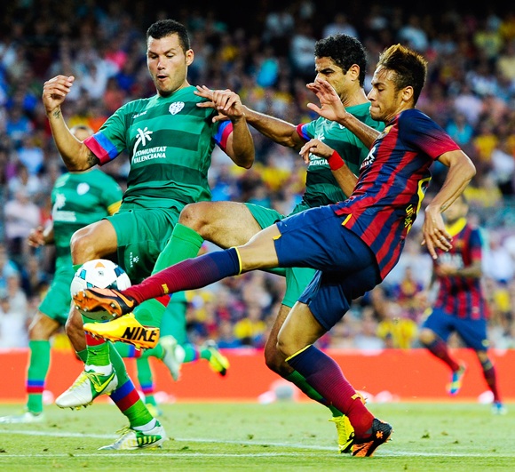 Neymar of FC Barcelona shoots towards goal under a challenge by Lenvate UD players