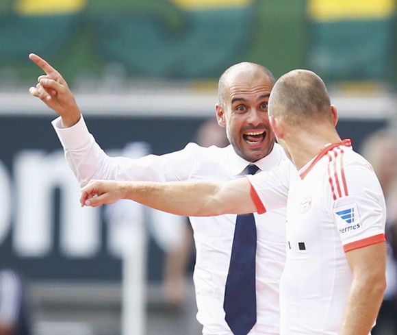Bayern Munich's coach Pep Guardiola (left) instructs Arjen Robben