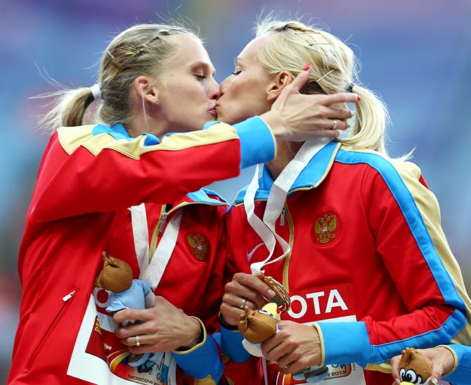 Tatyana Firova and Kseniya Ryzhova of Russia kiss on the podium during the medal ceremony for the women's 4x400 metres relay at the World Athletics Championships in Moscow