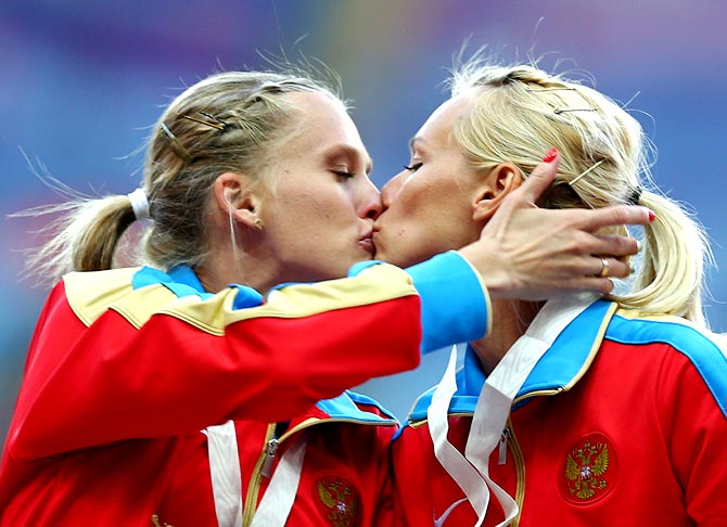 Tatyana Firova and Kseniya Ryzhova of Russia kiss on the podium during the medal ceremony for the women's 4x400 metres relay at the World Athletics Championships in Moscow