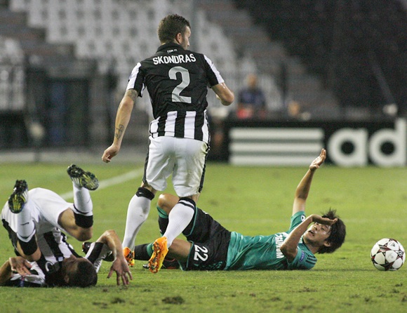 PAOK Salonika's Giannis Skondras (centre) is tackled by Schalke 04's Atsuto Uchida (right)