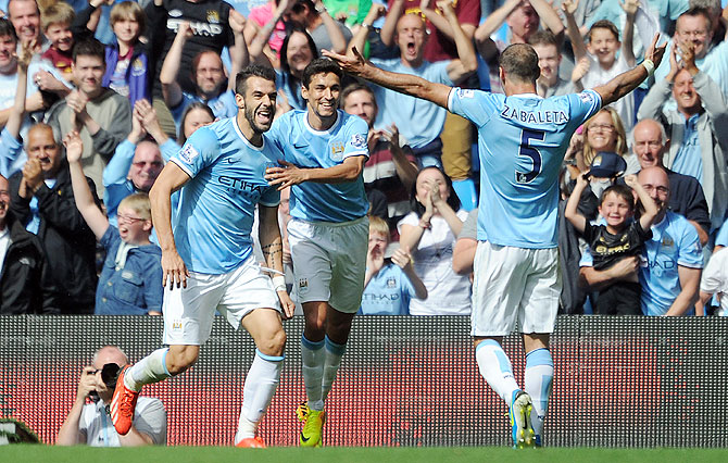 Manchester City's Alvaro Negredo (left) celebrates with teammates Jesus Navas and Pablo Zabaleta after scoring the opening goal of the Barclays Premier League match against Hull City at the Etihad Stadium in Manchester on Saturday