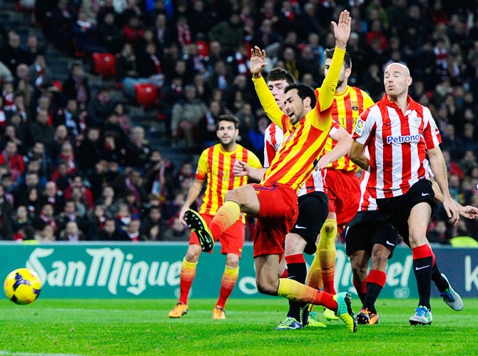 Sergio Busquets of FC Barcelona is brought down by Iker Muniain of Athletic Club