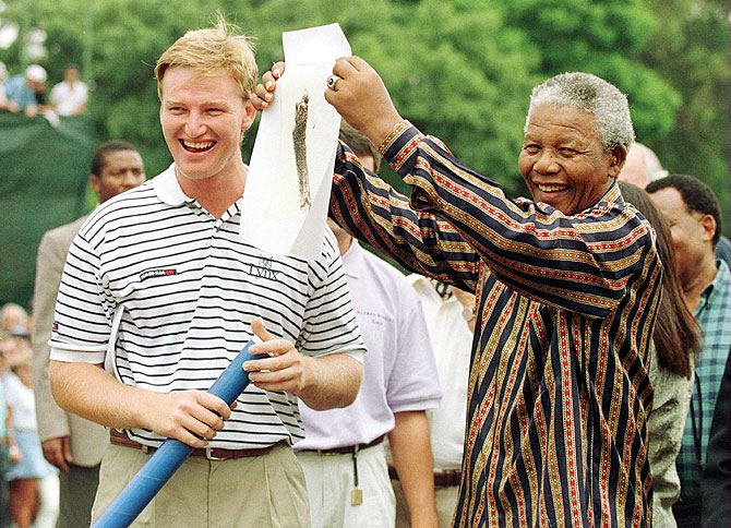 Ernie Els and President Nelson Mandela of South Africa share a laugh as Mandela shows a sketching of Els to the crowd before the final round of the Alfred Dunhill South African PGA Championship at Houghton Golf Club, Johannesburg, South Africa in February 1996