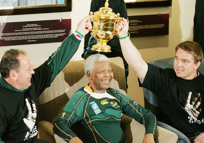Former South Africa President Nelson Mandela   poses with South Africa Rugby Union coach Jake White (left), South Africa Rugby Union captain John Smit (right) and the Webb-Ellis cup