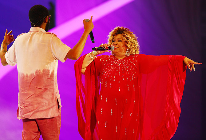 Alcione and Emicida perform on stage before the draw on Friday