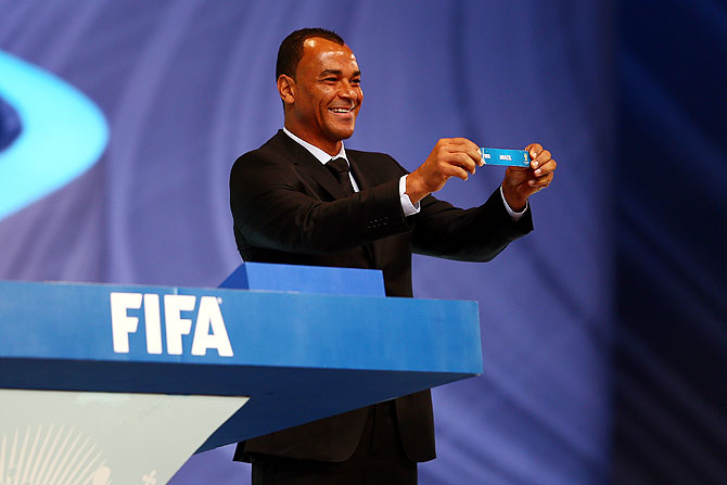 Draw assistant Cafu holds up the name of Brazil during the draw