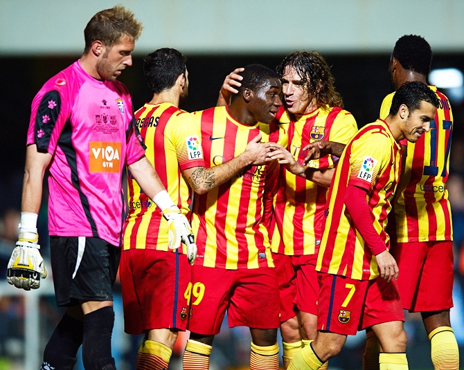 Dongou (second left) of Barcelona celebrates with his teammate Carles Puyol