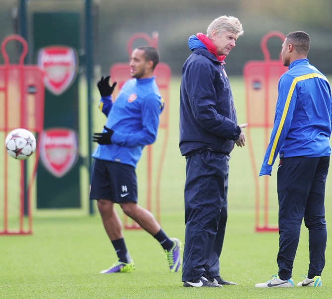Arsenal manager Arsene Wenger talks with player Serge Gnabry as Theo Walcott warms up