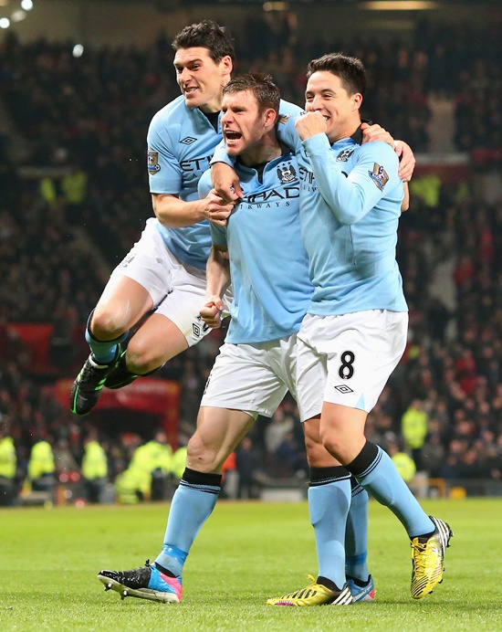 James Milner of Manchester City celebrates with his team-mates Gareth Barry (left) and Samir Nasri