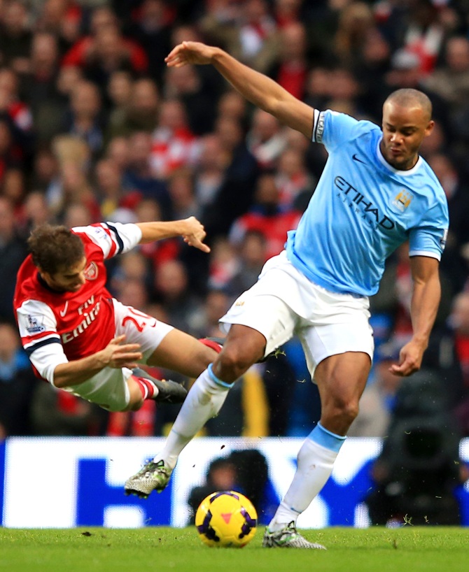 Mathieu Flamini of Arsenal clashes with Vincent Kompany of Manchester City