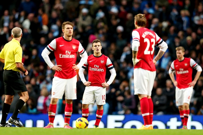Aaron Ramsey, Jack Wilshere and Nicklas Bendtner of Arsenal stand dejected