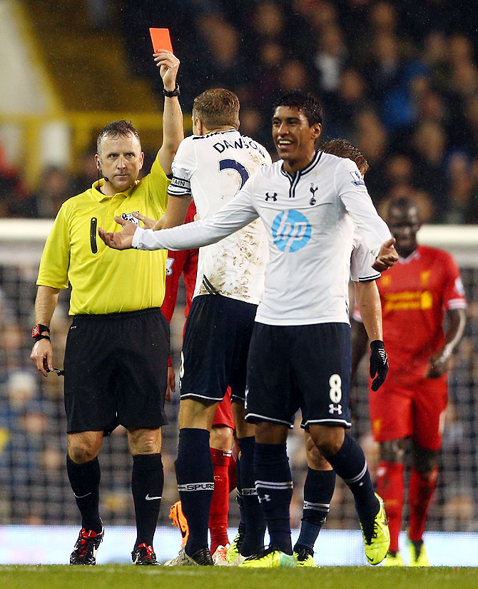 Referee Jonathan Moss shows Paulinho of Tottenham Hotspur a red card for a foul on Luis Suarez of Liverpool on Sunday