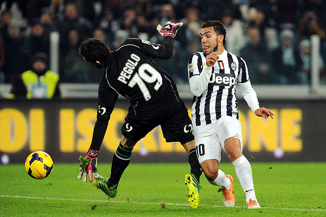 Carlos Tevez of Juventus (right) scores past goalkeeper Gianluca Pegolo of US Sassuolo Calcio