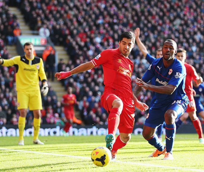 Luis Suarez (left) of Liverpool and Kevin Theophile-Catherine (right) of Cardiff City challenge for the ball