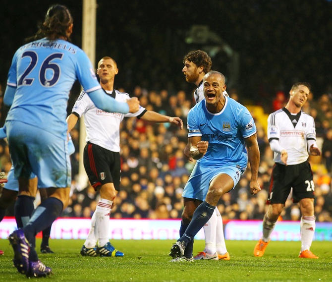 Vincent Kompany celebrates scoring their second goal with Martin Demichelis of Manchester City