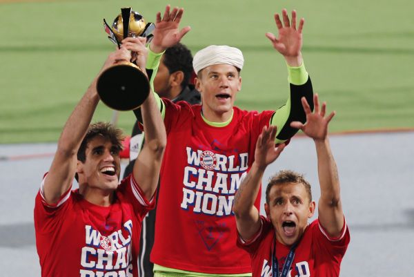 Javier Martinez (L) of Germany's Bayern Munich holds the trophy as he celebrates with goalkeeper Manuel Neuer (C) and Rafinha after winning their 2013 FIFA Club World Cup final 