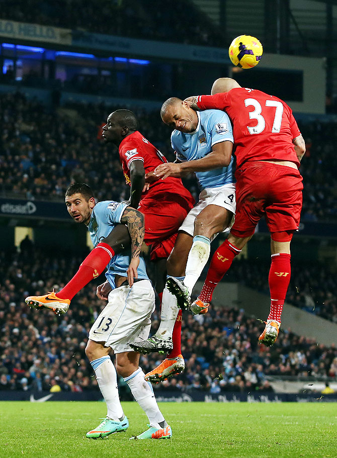 Martin Skrtel of Liverpool goes up for the ball with Vincent Kompany of Manchester City during their match at the Etihad Stadium on Thursday