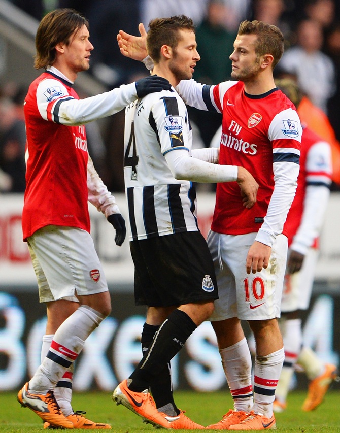 Jack Wilshere (right) of Arsenal shakes hands with Yohan Cabaye of Newcastle United as Tomas Rosicky of Arsenal looks