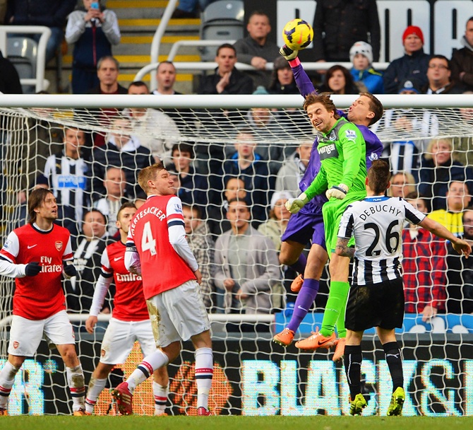 Goalkeeper Wojciech Szczesny of Arsenal punches clear as he is challenged by Newcastle goalkeeper Tim Krul