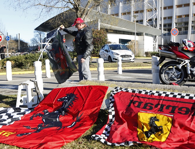 Dario, a Ferrari local fan, displays flags in front of the entrance of the emergency services at the CHU Nord hospital in Grenoble, French Alps, where retired seven-times   Formula One world champion Michael Schumacher is hospitalized after a ski accident