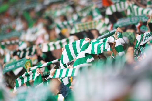 Fans hold aloft green scarves