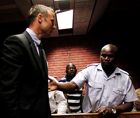 Oscar Pistorius is escorted by police during his court appearance in Pretoria