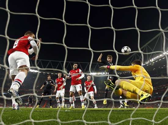 Bayern Munich's Thomas Muller (centre) scores a goal past Arsenal's goalkeeper Wojciech Szczesny