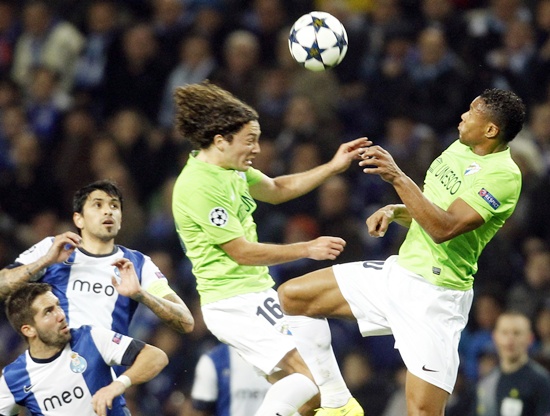 Porto's players (left) watch as Malaga's Manuel Iturra (centre) and Julio Baptista jump for the ball
