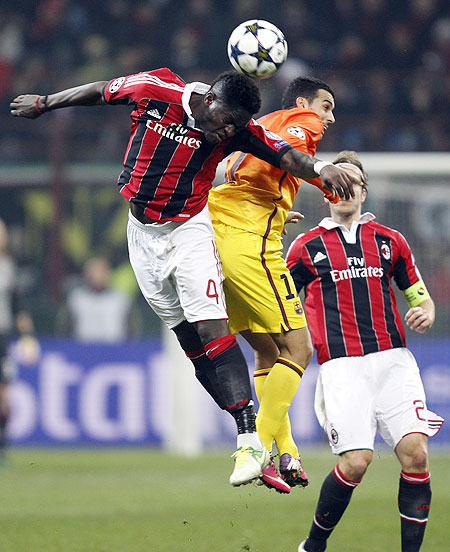 AC Milan's Sulley Muntari (left) and Barcelona's Pedro in an aerial challenge during their Champions League match on Wednesday