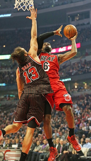 LeBron James of the Miami Heat goes up for a shot against Joakim Noah of the Chicago Bulls 