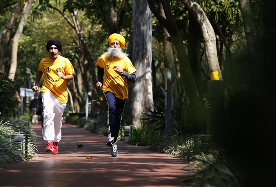 Fauja Singh (right) jogs with his coach Harmander Singh