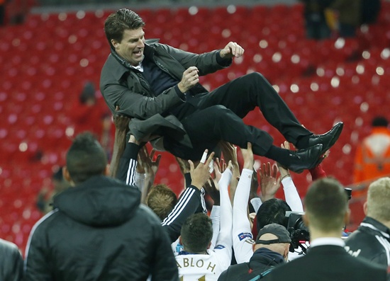 Swansea City's manager Michael Laudrup is tossed in the air by the players