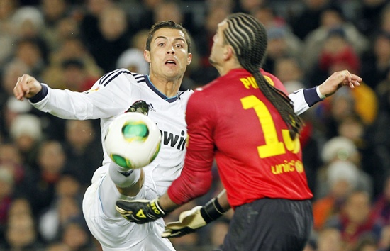 Real Madrid's Cristiano Ronaldo (left) chases Barcelona's goalkeeper Jose Manuel Pinto