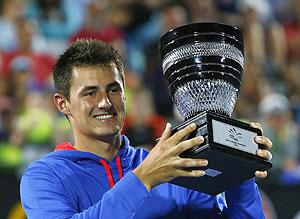 Bernard Tomic of Australia poses with the trophy after defeating Kevin Anderson of South Africa during their men's final match at the Sydney International tennis tournament on Saturday