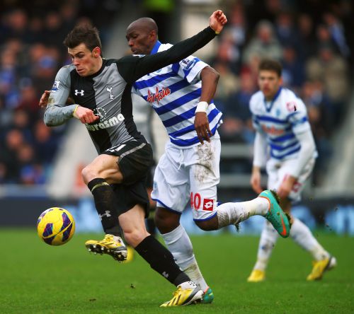 Gareth Bale (L) of Tottenham Hotspur holds off the challenge of Stephane Mbia (R) of Queens Park Rangers during the Barclays Premier League match