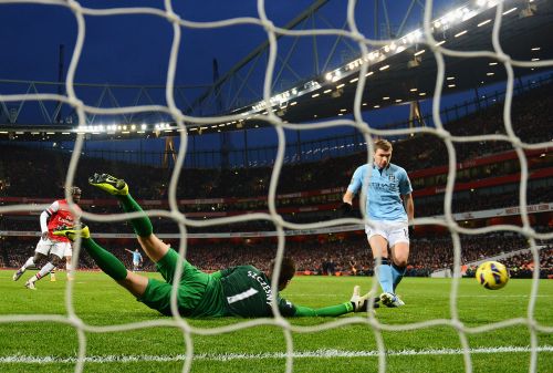 Edin Dzeko of Manchester City shoots past Wojciech Szczesny of Arsenal to score their second goal during the Barclays Premier League match between Arsenal and Manchester City