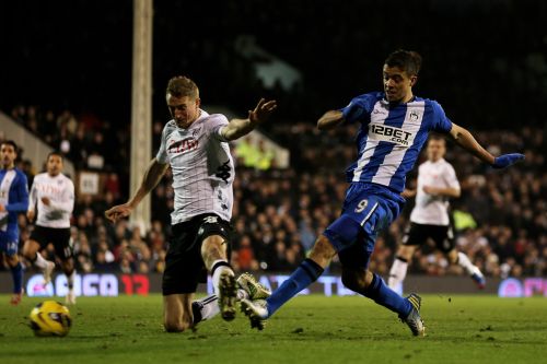 Franco Di Santo of Wigan shoots on goal past the challenge from Brede Hangeland of Fulham during the Barclays Premier League match between Fulham and Wigan Athletic