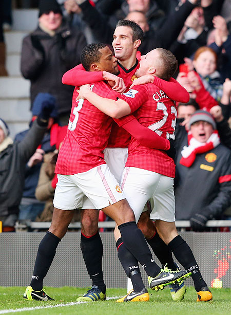 Manchester United's Robin van Persie celebrates with teammates Patrice Evra (left) and Tom Cleverley after scoring the opening goal against Liverpool