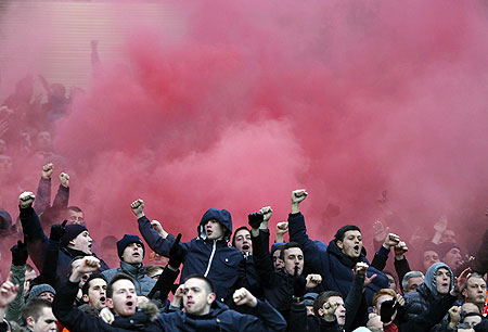 Liverpool fans react as a flare is lit up in the stands during the English Premier League match against Manchester United on Sunday