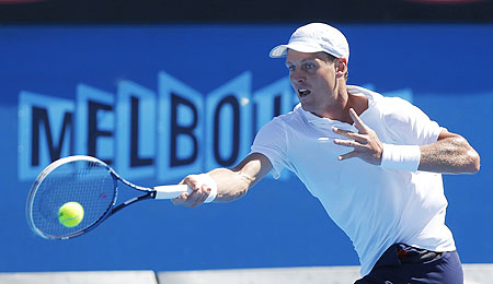 Tomas Berdych of Czech Republic hits a return to Michael Russell of the US during their first round match