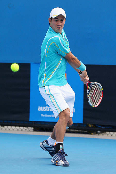 Kei Nishikori of Japan plays a backhand in his first round match against Victor Hanescu of Romania