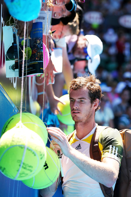 Andy Murray of Great Britain signs an autograph after winning